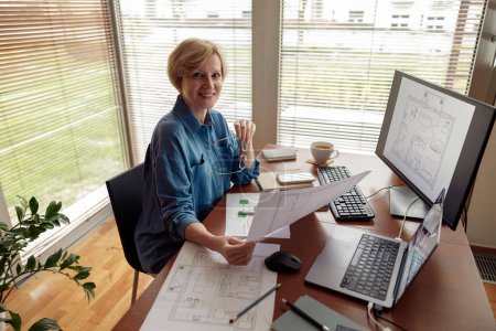 Photo for Mature woman interior designer works on project from home office using computer. High quality photo - Royalty Free Image