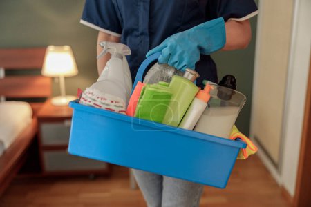 Téléchargez les photos : Femme de nettoyage professionnelle tient boîte avec des détergents et des chiffons. Photo de haute qualité - en image libre de droit