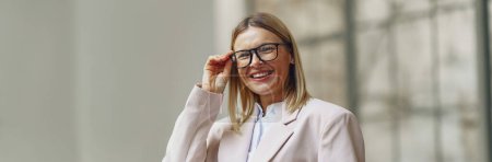 Téléchargez les photos : Portrait de femme d'affaires souriante avec carnet debout sur fond de bureau. Photo de haute qualité - en image libre de droit