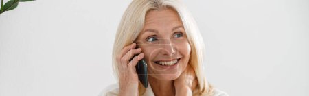 Téléchargez les photos : Belle femme blonde caucasienne dans la clinique de cosmétologie de lumière moderne appelant sur téléphone portable, gros plan - en image libre de droit