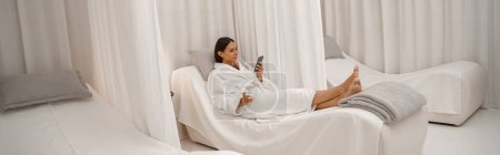 Téléchargez les photos : Jolie jolie femme en peignoir blanc profitant tout en se reposant avec une tasse de café dans le salon de spa - en image libre de droit