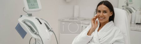 Téléchargez les photos : Femme en peignoir blanc pendant la procédure médicale en clinique de beauté. Photo de haute qualité - en image libre de droit