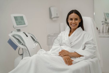 Téléchargez les photos : Femme en peignoir blanc pendant la procédure médicale en clinique de beauté. Photo de haute qualité - en image libre de droit