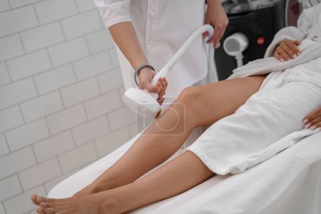 Photo for Hair removing procedure of legs. Laser epilation and cosmetology in beauty salon. High quality photo - Royalty Free Image