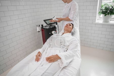Foto de Cosmetólogo está haciendo cavitación rejuvenecimiento tratamiento de la piel. Elevación de ondas de radio - Imagen libre de derechos