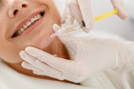 Téléchargez les photos : Esthéticienne médecin mains faisant procédure de beauté au visage féminin senior avec seringue, injection de charge - en image libre de droit