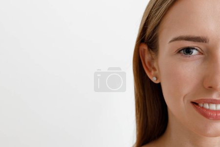 Téléchargez les photos : Femme tendre avec un visage parfait regardant la caméra sur fond de studio blanc. Photo de haute qualité - en image libre de droit