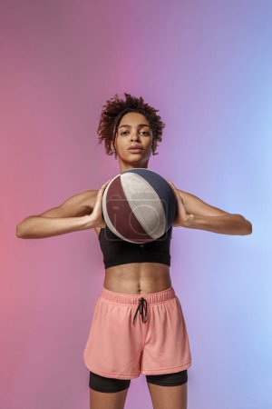 Téléchargez les photos : Belle joueuse de basket après le jeu sur fond studio avec filtre de couleur - en image libre de droit