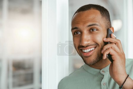 Photo for Smiling african businessman talking phone with client while standing in office. Blurred background - Royalty Free Image