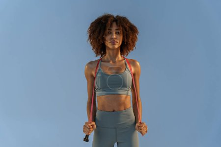 Photo for Portrait of smiling athletic woman with jump rope on studio background. High quality photo - Royalty Free Image
