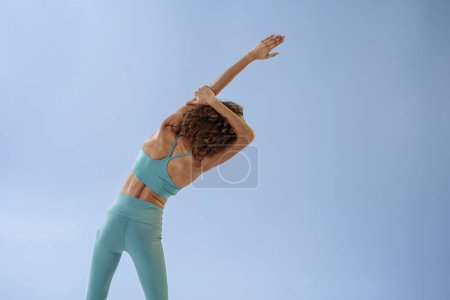 Photo for Sporty woman doing warm-up before training session in gym on studio background. High quality photo - Royalty Free Image
