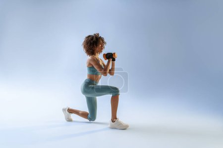 Téléchargez les photos : Femme faisant des exercices avec haltères sur fond de studio. Sport et mode de vie sain - en image libre de droit
