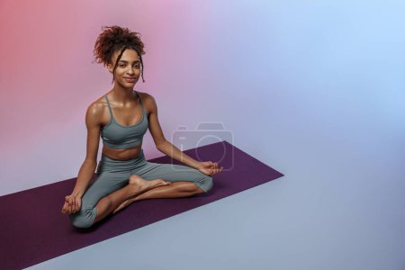 Foto de Mujer fitness practicando yoga sobre estera sobre fondo de estudio con filtro de color. Foto de alta calidad - Imagen libre de derechos
