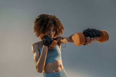 Foto de Mujer muscular haciendo ejercicio con pesas pesadas sobre fondo de estudio - Imagen libre de derechos