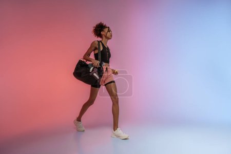 Téléchargez les photos : Femme va à l'entraînement avec bouteille d'eau, sac de sport et pomme sur fond de studio - en image libre de droit