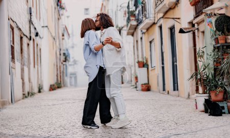 Téléchargez les photos : Couple amoureux embrasser et sourire dans la rue de la ville pendant les vacances d'été. Photo de haute qualité - en image libre de droit