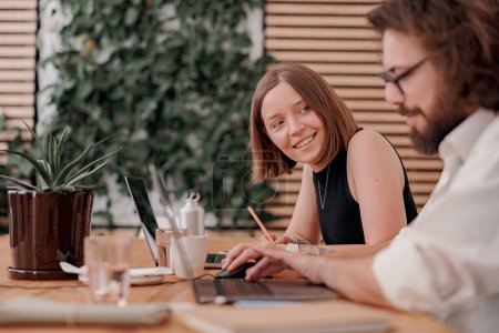 Photo for Smiling man and woman freelancers talking during working day in modern coworking. High quality photo - Royalty Free Image