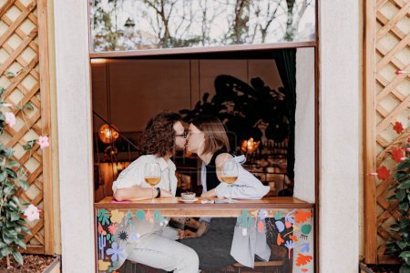 Foto de Pareja enamorada besándose durante la cita mientras está sentada en el bar y bebiendo vino. Foto de alta calidad - Imagen libre de derechos