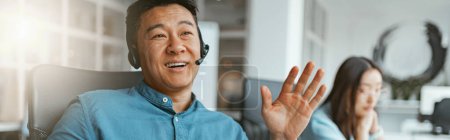 Photo for Smiling asian businessman talking phone with client while sitting in office. Blurred background - Royalty Free Image