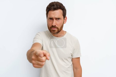 Photo for Strict man in t-shirt standing on white background and pointing finger to camera. High quality photo - Royalty Free Image