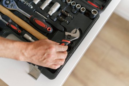 Photo for Close up of professional handyman hand with open tool bag full of equipment. High quality photo - Royalty Free Image