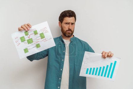 Foto de Freelancer masculino o vendedor mostrando sus gráficos de ventas y plan de negocios sobre fondo blanco - Imagen libre de derechos