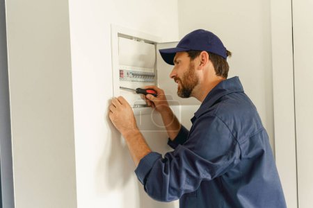 Téléchargez les photos : Électricien inspecter et réparer les systèmes électriques dans les maisons et les bâtiments. Photo de haute qualité - en image libre de droit