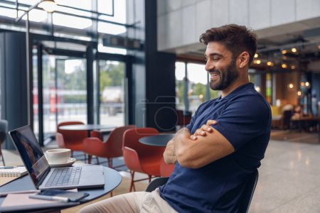Téléchargez les photos : Beau mâle freelance prendre l'ordre du client via webcam assis dans le coworking - en image libre de droit