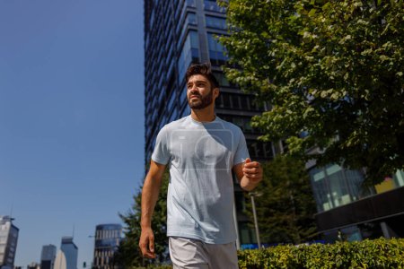 Foto de Hombre atleta corredor de entrenamiento en la calle de la ciudad en el fondo de los rascacielos. concepto de estilo de vida saludable - Imagen libre de derechos