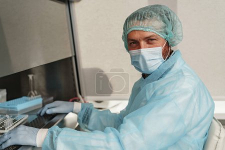 Photo for Male scientist in uniform and mask working in medical research laboratory. High quality photo - Royalty Free Image