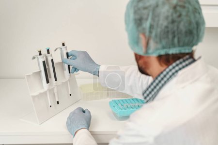 Téléchargez les photos : Homme scientifique en uniforme travaillant dans un laboratoire de recherche médicale. Photo de haute qualité - en image libre de droit