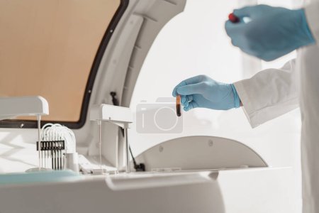 Photo for Close up of scientists hand in gloves putting a small plastic test tube in a microcentrifuge - Royalty Free Image