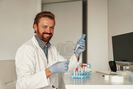 Téléchargez les photos : Un scientifique dépose une substance dans une éprouvette dans un laboratoire de recherche. Concept de science et de biochimie - en image libre de droit