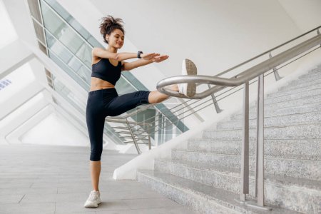 Foto de Mujer deportiva hace ejercicios de calentamiento por la mañana antes de correr el entrenamiento al aire libre. Aptitud saludable - Imagen libre de derechos