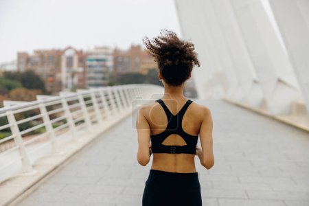 Téléchargez les photos : Athlète femme active fait du jogging le matin sur fond de bâtiment moderne. Concept de vie saine - en image libre de droit