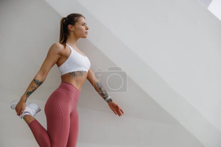 Photo for Sporty woman does warm-up exercises in morning before running training outside. Healthy fitness - Royalty Free Image