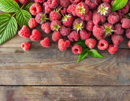 Foto de Frambuesas rojas dulces frescas con fondo de madera dispuestos juntos que representan el concepto de dieta saludable. Copiar espacio - Imagen libre de derechos