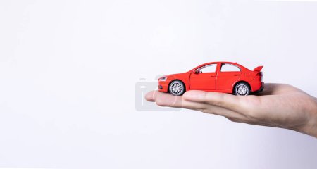 Téléchargez les photos : Main tenant une voiture jouet isolée sur fond de dégradé. Après quelques modifications. - en image libre de droit