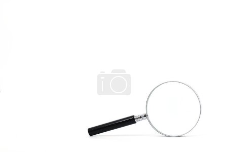 Photo for An image of a magnifying glass with a black handle and a silver rim around the magnifying glass, set against a pristine white backdrop. - Royalty Free Image