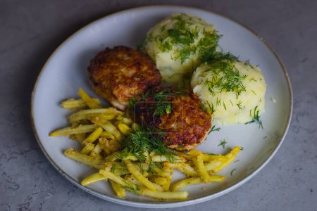 Classic Polish cuisine: pork mince burgers, mashed potatoes, yellow wax beans, breadcrumb-topped, garnished with finely chopped dill. 