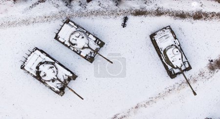 Aerial view of snow-clad tanks in Poznan Citadel during winter, shot by drone.