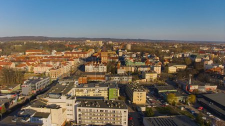 A drone shot captures Koszalin city center bathed in golden light, featuring the cathedral, Victory Street, and town hall.