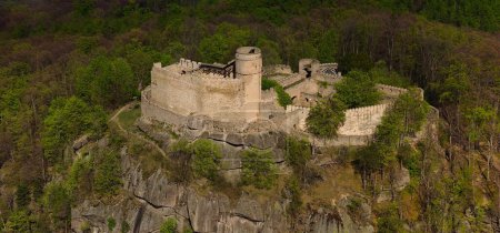 Eine Luftaufnahme zeigt die mittelalterliche Burg Chojnik auf einem Berg im Riesengebirge. Die antike Festung steht stolz inmitten der malerischen Landschaft und vereint Geschichte mit Natur.