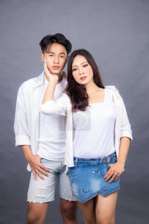 Photo for Man and woman posing standing in front of camera hands holding cheeks indoor man. promotional couple photo session in the studio - Royalty Free Image