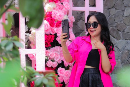 Beauty asian girl in pink shirt glasses candid happy hand pointing business cellphone for fashion, lifestyle, banner, promo content