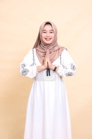 Foto de Retrato de una hermosa joven musulmana asiática vestida con un alegre hiyab posando para dar la bienvenida a Ramadán y Eid. para publicidad, contenido, banners y Ramadán - Imagen libre de derechos