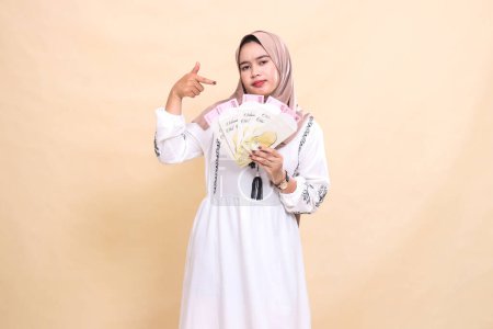 Foto de Retrato de una hermosa mujer musulmana indonesia con un hiyab plano mostrando regalos y regalos en el Eid. utilizado para la publicidad, regalos, Eid y Ramadán - Imagen libre de derechos