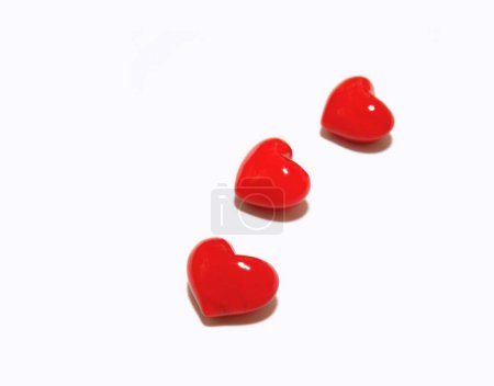 Téléchargez les photos : Trois cœurs rouges brillants sont courbes et alignés. - en image libre de droit
