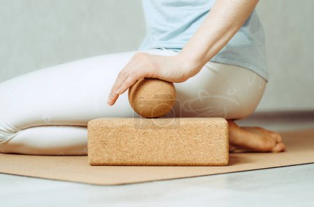 Photo for Woman doing palmar fascia release with cork ball on a cork block - Royalty Free Image