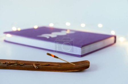 Foto de Cerrar palo de incienso quema con un diario de la luna y luces de Navidad de fondo - Imagen libre de derechos